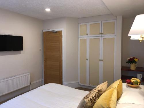 a bedroom with a bed and a tv on the wall at Tully's Hotel in Castlerea