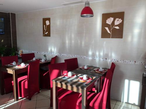 a dining room with two tables and red chairs at HOTEL RESTAURANT PARIS PACIFIC PARIS-VILLEJUIF- PRES DU METRO L'HAY LES ROSES LIGNE 14 - Direct PARIS-AEROPORT ORLY ET INSTITUT GUSTAVE ROUSSI in Villejuif