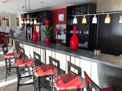 a bar with red chairs and red vases at HOTEL RESTAURANT PARIS PACIFIC PARIS-VILLEJUIF- PRES DU METRO L'HAY LES ROSES LIGNE 14 - Direct PARIS-AEROPORT ORLY ET INSTITUT GUSTAVE ROUSSI in Villejuif