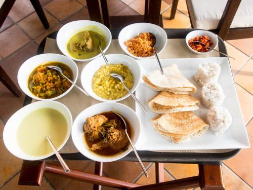 a table topped with bowls of different types of food at Leonine Villa Yala in Tissamaharama