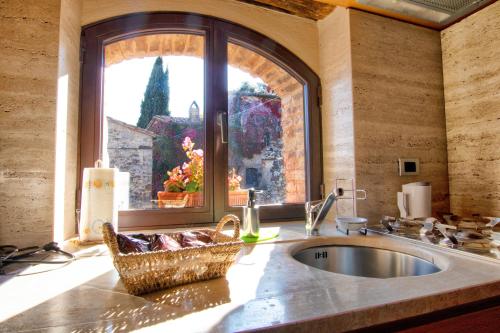 a kitchen with a sink and a large window at Larocchettina in Castiglione dʼOrcia