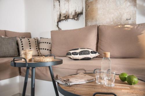 a living room with a couch and a table at Perla Suites - Delmar Collection in Pollonia