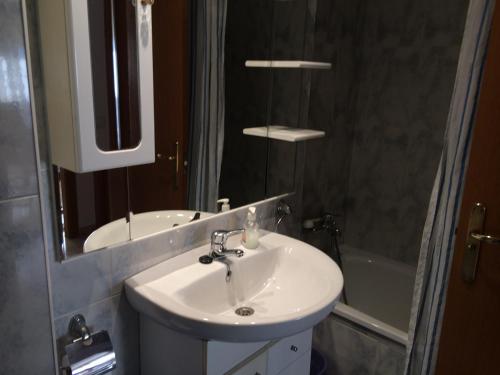 uma casa de banho com um lavatório, um espelho e uma banheira em Llastre em Hospitalet de l'Infant