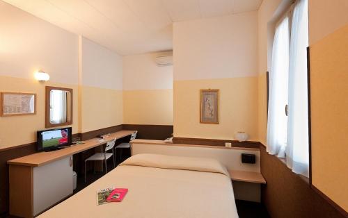 a hospital room with a bed and a desk at Hotel Eden in Baveno