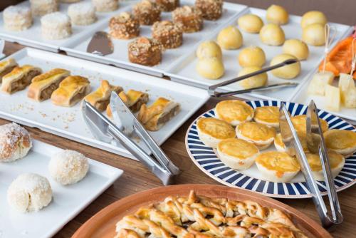 a table topped with plates of pastries and desserts at Ilha Branca Exclusive Hotel in Búzios