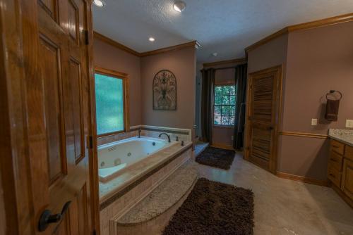 ein großes Bad mit einer großen Badewanne und einem Fenster in der Unterkunft The Pointe in Greensboro