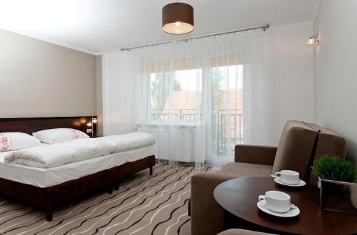 ウストロニエ・モルスキエにあるDom Wypoczynkowy Arpolのベッドルーム1室(ベッド1台付)、リビングルームが備わります。