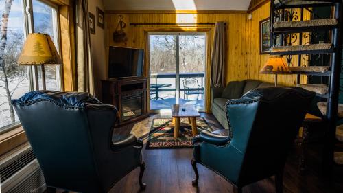 a living room with two chairs and a television at Curriers Lakeview Lodge in Rice Lake