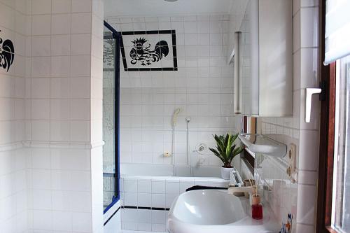 ein weißes Badezimmer mit einer Badewanne und einem Waschbecken in der Unterkunft Ferienhaus Dell in Möhnesee
