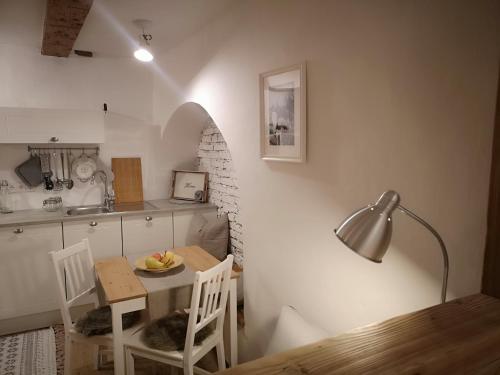eine kleine Küche mit einem Tisch, Stühlen und einer Lampe in der Unterkunft Space Nr. 11 in Meran