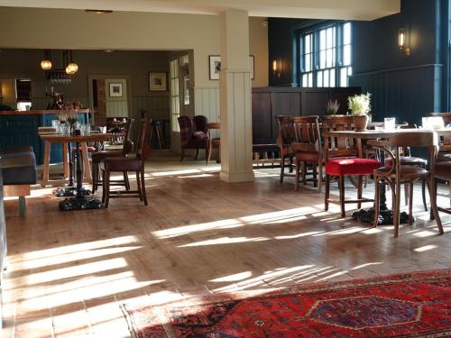 d'une salle à manger lumineuse avec des tables et des chaises en bois. dans l'établissement The Devonport, à Darlington