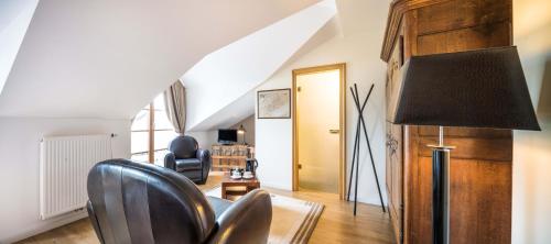 a living room with a chair and a lamp at Auberge Du Relais Postal in Asselborn