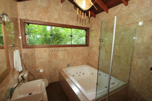 La salle de bains est pourvue d'une baignoire, d'une douche et d'un lavabo. dans l'établissement Hotel Cabanas, à Bonito