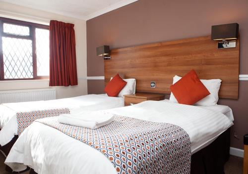 a hotel room with two beds and a window at Griffin Inn in Newquay