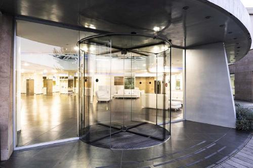 a room with a large glass elevator in a building at A Point Arezzo Park Hotel in Arezzo