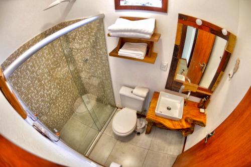 a small bathroom with a toilet and a shower at Casinhas da Julieta in Morro de São Paulo