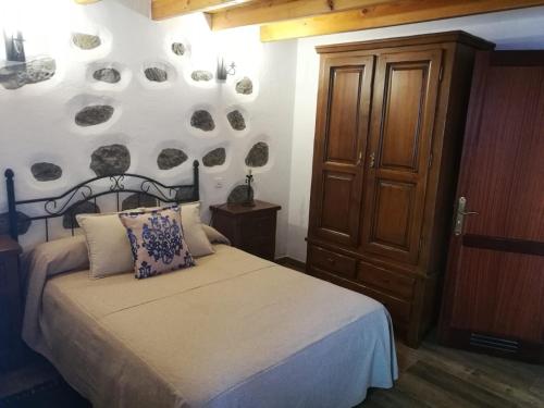 a bedroom with a bed and a wall with plates at Casa Naranjo in Ayacata