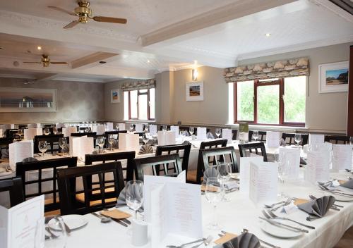 un comedor con mesas blancas y sillas negras en Griffin Inn en Newquay