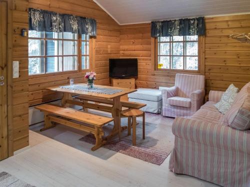 uma sala de estar com uma mesa e um sofá em Holiday Home Rukantaika 1a by Interhome em Virkkula