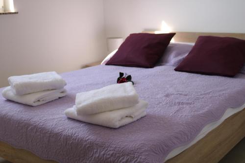 een bed met handdoeken en een kat bovenop bij Nin Ždrijac 2 in Nin