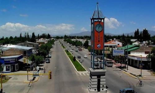 a town with a clock tower in the middle of a street at El Pasaje in Malargüe