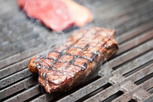 two pieces of meat cooking on a grill at Griffin Inn in Newquay