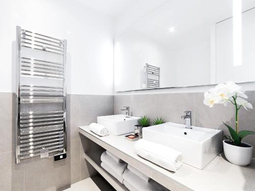 une salle de bain avec deux lavabos et un miroir dans l'établissement LivinParis - Luxury 3 Bedrooms République I, à Paris