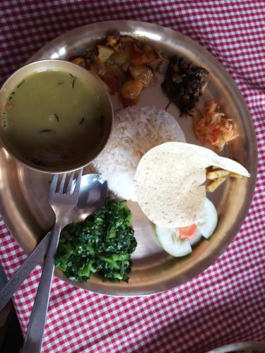 un piatto di cibo con riso e una ciotola di zuppa di Hotel Lotus Inn a Pokhara