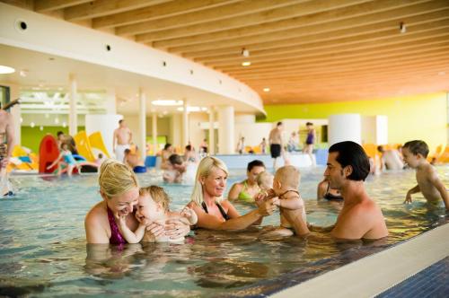 a group of people in a swimming pool at All in Red Thermenhotel in Lutzmannsburg