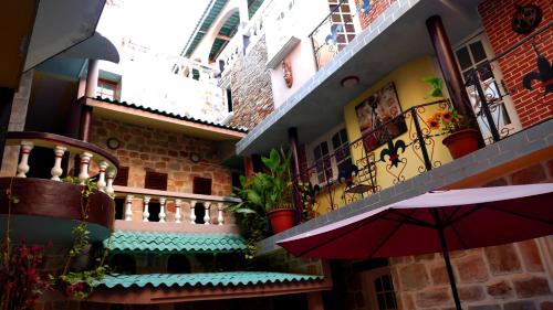 a building with a red umbrella in a courtyard at Résidence Hôtelière Océane in Lomé