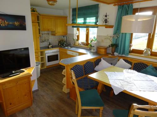 a kitchen with a table and a dining room at Pension Tannenhof in Leogang