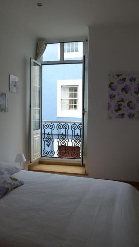 a bedroom with a bed and a large window at Watching Azores Apartment in Ponta Delgada