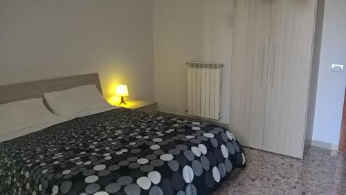 a bedroom with a black and white bed and a lamp at Ercole in riposo in Caserta