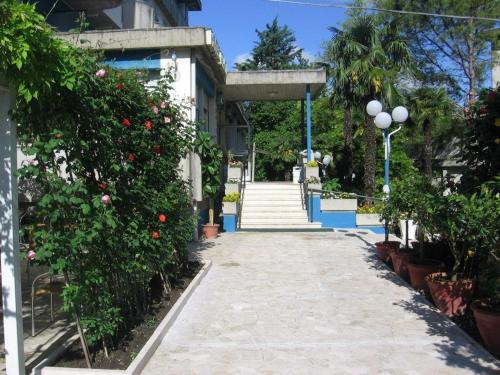 a walkway leading up to a building with flowers at Hotel Prati in Castrocaro Terme