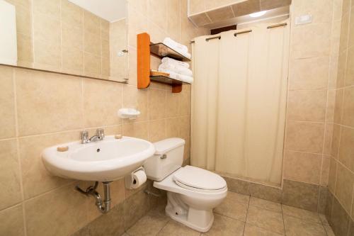 a bathroom with a toilet and a sink at Hotel Chavín in Barranca