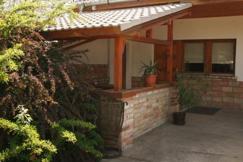 a house with a brick wall and a patio at Vendégház 60 in Hatvan