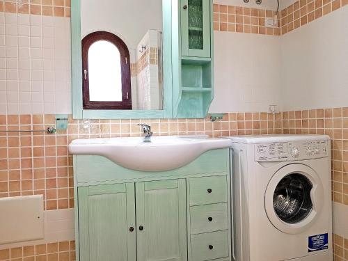 a bathroom with a sink and a washing machine at villette acquamarina Budoni in Budoni