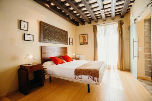 Schlafzimmer mit einem Bett mit roten Kissen und einem Fenster in der Unterkunft Loft del Arte in Cádiz