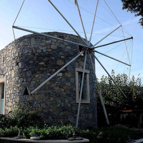 a stone building with a windmill on top of it at Authentic Cretan Stone Windmill in Sitia