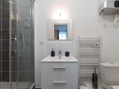a white bathroom with a sink and a shower at Le Nid Lyonnais - Montchat in Lyon