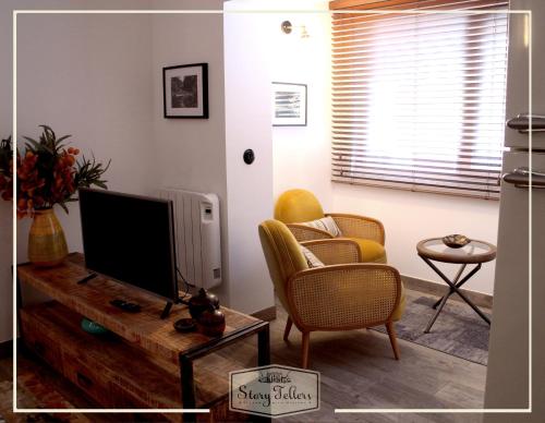a living room with two chairs and a flat screen tv at Storytellers Villas in Sintra