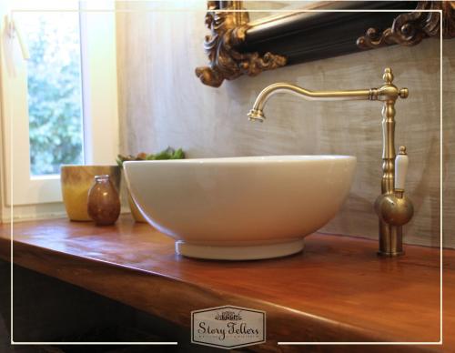 a bowl sink on a wooden counter with a gold faucet at Storytellers Villas in Sintra