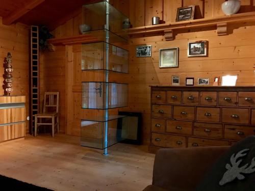 シェーナウ・アム・ケーニッヒスゼーにあるHaus Junaの木製の壁の客室で、ガラスの本棚が備わります。