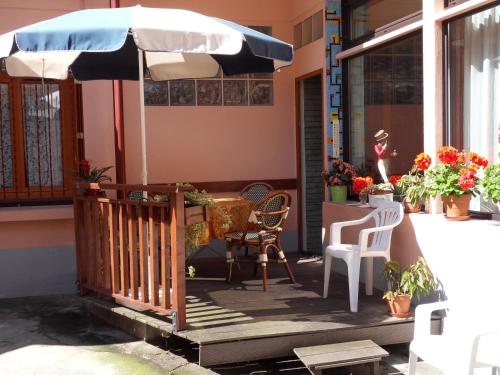 a porch with an umbrella and a table and chairs at Hôtel Victoria in Grenoble