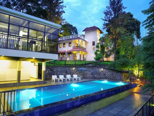 Hotel Treetop في تيكادي: منزل به حوض سباحة أمام المنزل