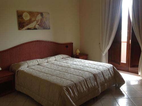 sypialnia z łóżkiem w pokoju z oknem w obiekcie Monte Degli Ulivi Country House w mieście Mercato San Severino