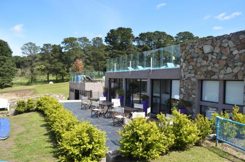 a building with tables and chairs outside of it at Posta Natural in Tandil