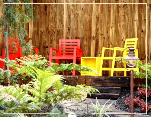 a group of colorful chairs in front of a fence at Storytellers Villas in Sintra