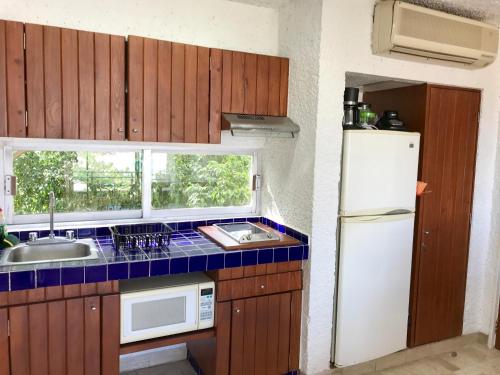 a kitchen with a sink and a white refrigerator at Hotel Pacifica Departamento 2220 in Ixtapa