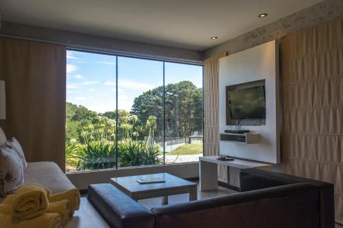 a living room with a couch and a large window at Posta Natural in Tandil
